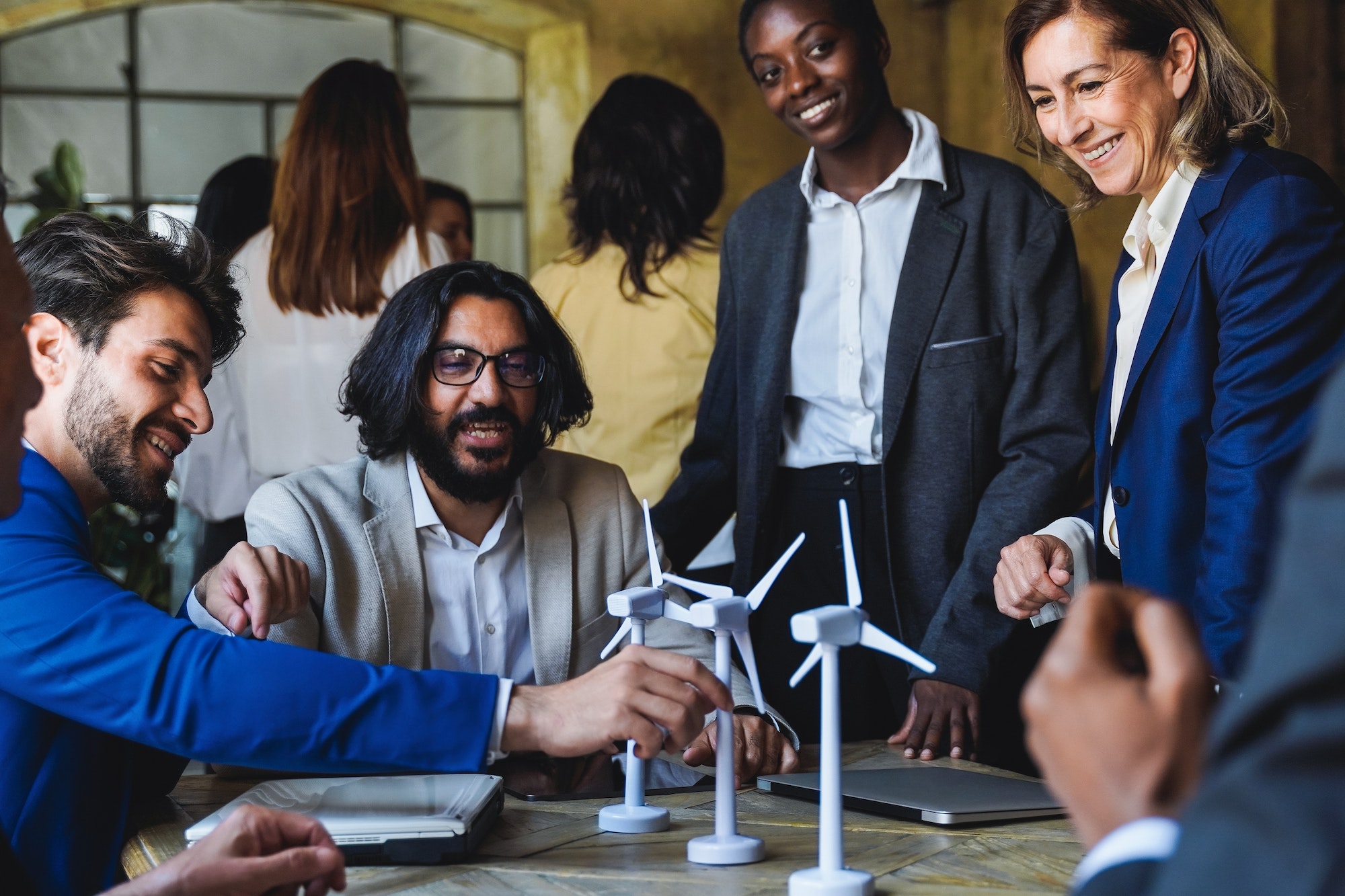 Happy business people work on sustainable renewable energy project inside office - Eco electricity